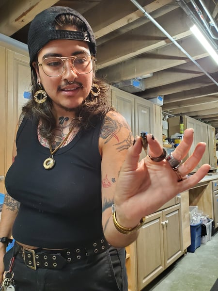 A person with tattoos poses with a cicada.