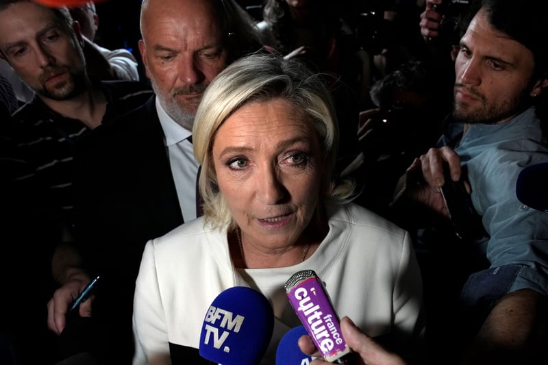 Marine Le Pen speaks into microphones.