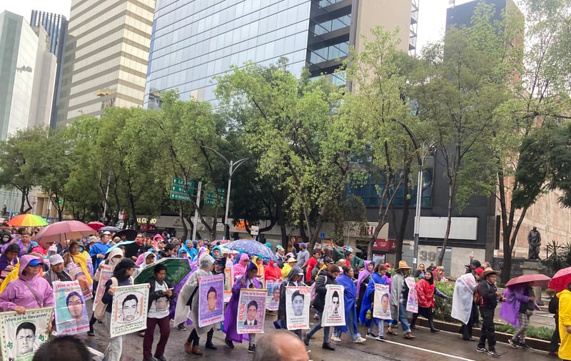 Parents of missing students march in Mexico City in the rain.