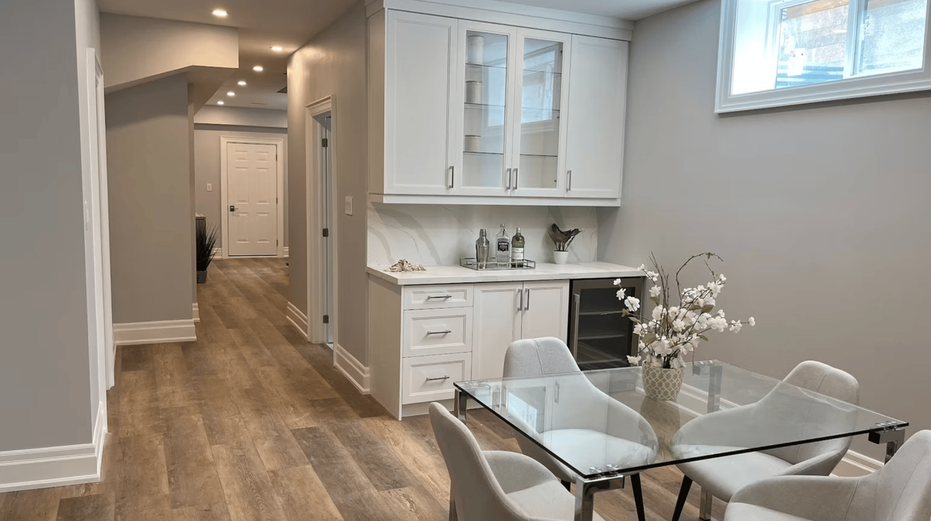 Basement kitchen and bar installation with seating area and built-in cabinetry