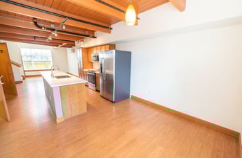 Union Bay Lofts rental: Seattle apartment interior with bright living area, modern kitchenette, and large window.