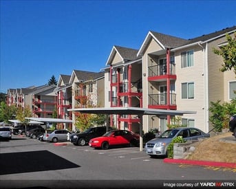 Chianti Apartments, Renton WA: bright living room with large window, modern furnishings, hardwood-style floor.