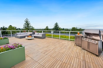 A wooden deck with a grill and seating area.