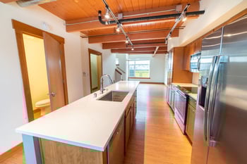 Union Bay Lofts Seattle apartment living room with bright large windows and modern kitchen; ideal rental