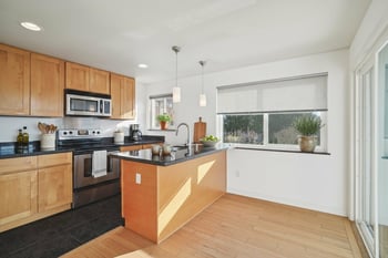 A kitchen with wooden cabinets and a black countertop.