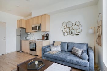 a living room with a couch and a kitchen
