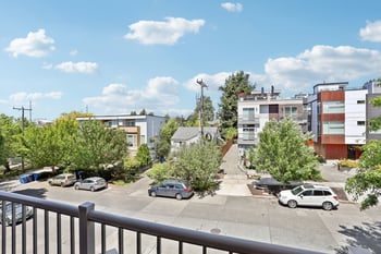 the view from a balcony of a parking lot with cars