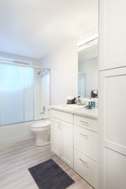 a bathroom with white cabinets and a white toilet
