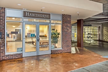 A Hawthorne storefront with a glass door and a brick wall.