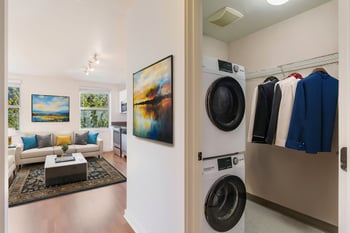 Living room at Gilbert House Apartments, Seattle, WA: bright space with large windows, wood flooring, and neutral decor.