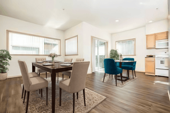A dining room with a table and chairs.