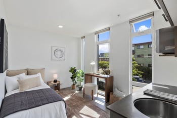 a bedroom with a bed and a large window