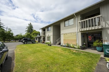 A car is parked on a driveway in front of a house.