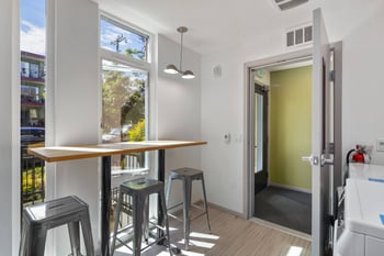 a kitchen with a counter and three stools in front of a window