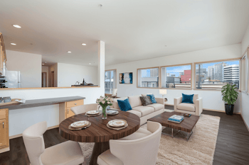 A modern living room with a dining table set for two.