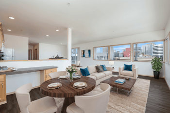 A modern living room with a dining table set for two.