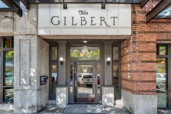 Gilbert House Apartments, Seattle: sunlit living room with cozy seating, ideal rental space.