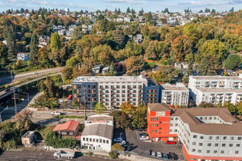 Aerial view of Harbor Flats apartment building amidst a tree-lined Seattle neighborhood with autu...