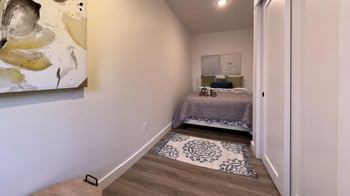 a bedroom with a bed and a painting on the wall