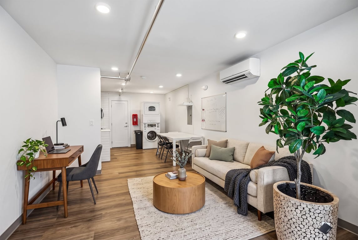 Open concept living space with a work desk, in-unit stacked washer/dryer, dining area, and living...