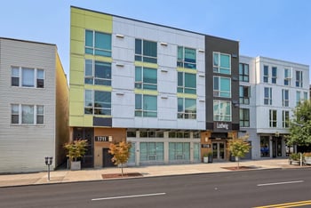 Street view of Ludwig Apartments showing modern facade with green and white panels.