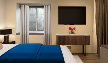 a hotel room with a bed and a tv in it