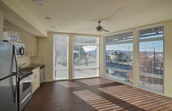 Bright living room in Larson Building apartment, Seattle, WA, with large windows and modern decor.