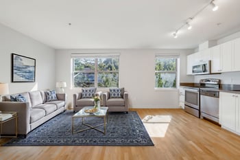Bright living room at Gilbert House Apartments, Seattle, WA featuring natural light, seating area, and modern finishes.