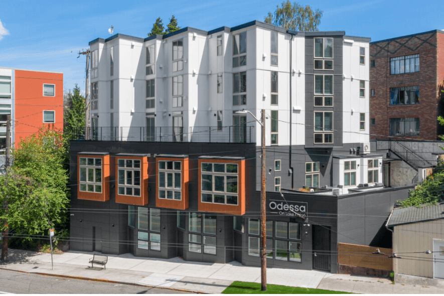 Modern exterior of the Odessa apartment building, featuring white and dark gray siding with large...