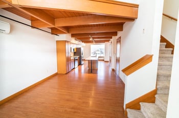 Living room at Union Bay Lofts, Seattle, WA: large windows, hardwood floors, and a modern kitchen.