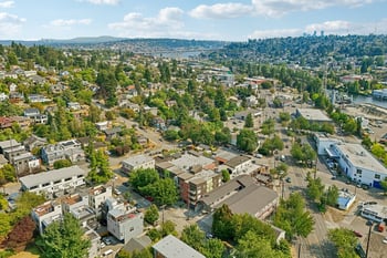 Aerial view of REV Fremont and the surrounding Seattle neighborhood with tree-lined streets and distant bridge.