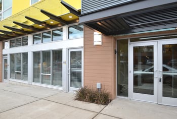 Exterior of Ludwig Apartments with modern facade, welcoming glass entrance doors, and large groun...