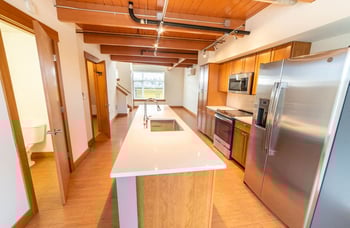 Union Bay Lofts Seattle apartment living room with large windows, modern finishes, and warm decor.
