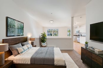 Bright 1-bedroom living room at Gilbert House Apartments, Seattle, WA, with wood floors and large windows.