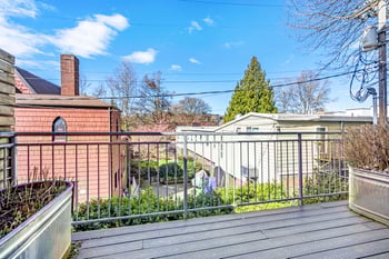 Interior of a Ludwig Apartments rental in Seattle: bright living area with contemporary kitchen and large window.