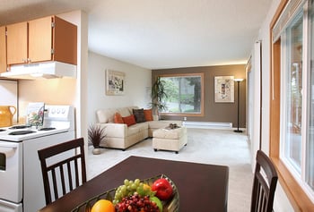Bright living room at Hill Crest Apartments, Tukwila, WA for rent; open-concept layout with large windows.