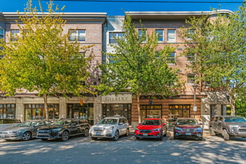 Gilbert House Apartments, Seattle — sunny living room with modern furnishings and large windows.