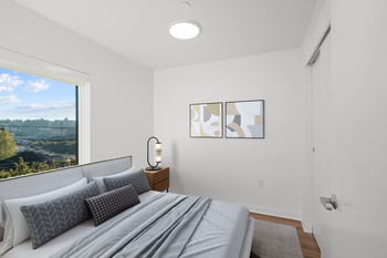 a bedroom with a bed and a large window