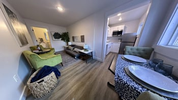a living room and dining room with a table and chairs