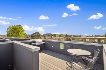 a patio with a table and chairs on a roof