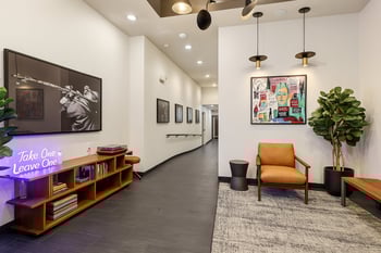 Stylish common area or lobby at Ludwig Apartments with a modern armchair, a book exchange shelf, ...