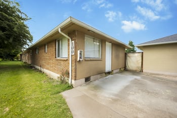 A house with a brown brick exterior and a white garage door.
