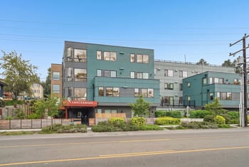 Street view of Lanterman Apartments showing the entrance sign, private balconies, and landscaped frontage.