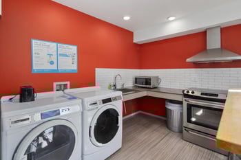 a laundry room with a washer and dryer and a sink and a microwave