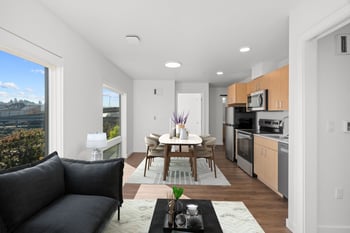 a living room with a couch and a table and a kitchen