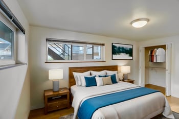 Bedroom with a bed, window, and artwork on the walls.