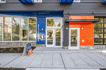 Exterior of Keystone Apartments building with main entrance 9208, blue and orange panels, and a N...