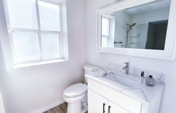 A white toilet sits next to a sink in a bathroom.