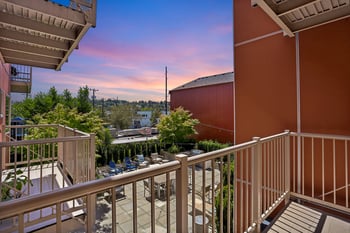 a balcony with a view of the city at sunset