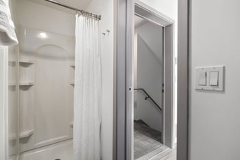 a bathroom with a shower and a staircase in a hotel room